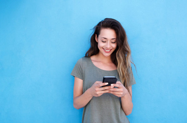 Woman smiling while using her phone